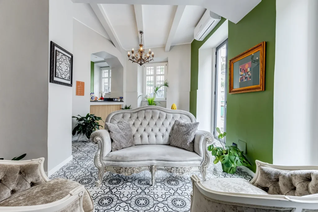 Area lounge elegante del boutique hotel a Messina con divano in stile classico e reception